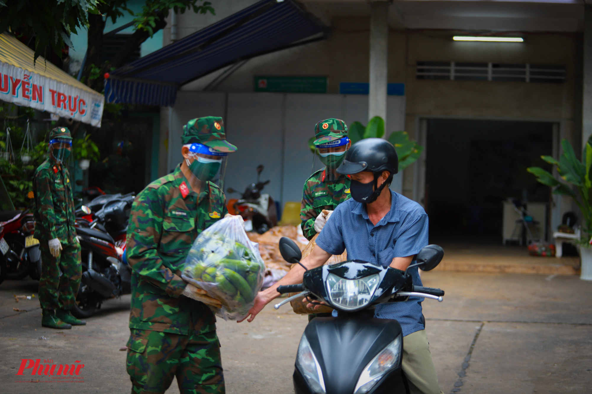 Tại phường 1, quận 8, chiến sĩ bộ đội vận chuyển h&agrave;ng h&oacute;a ra xe cho người d&acirc;n