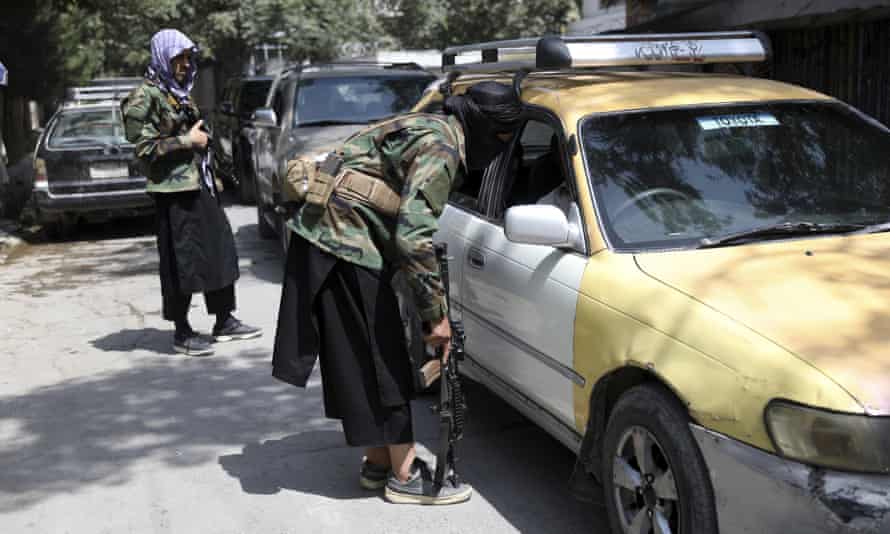 C&aacute;c chiến binh Taliban kh&aacute;m x&eacute;t một chiếc xe tại một trạm kiểm so&aacute;t tr&ecirc;n đường ở khu vực Wazir Akbar Khan của Kabul, Afghanistan,