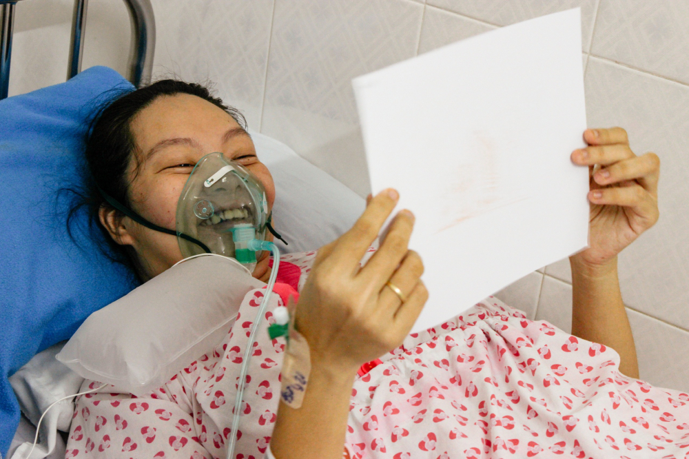 Nụ cười hạnh ph&uacute;c của một người mẹ đang đang điều trị khi nhận được ảnh con m&igrave;nh.