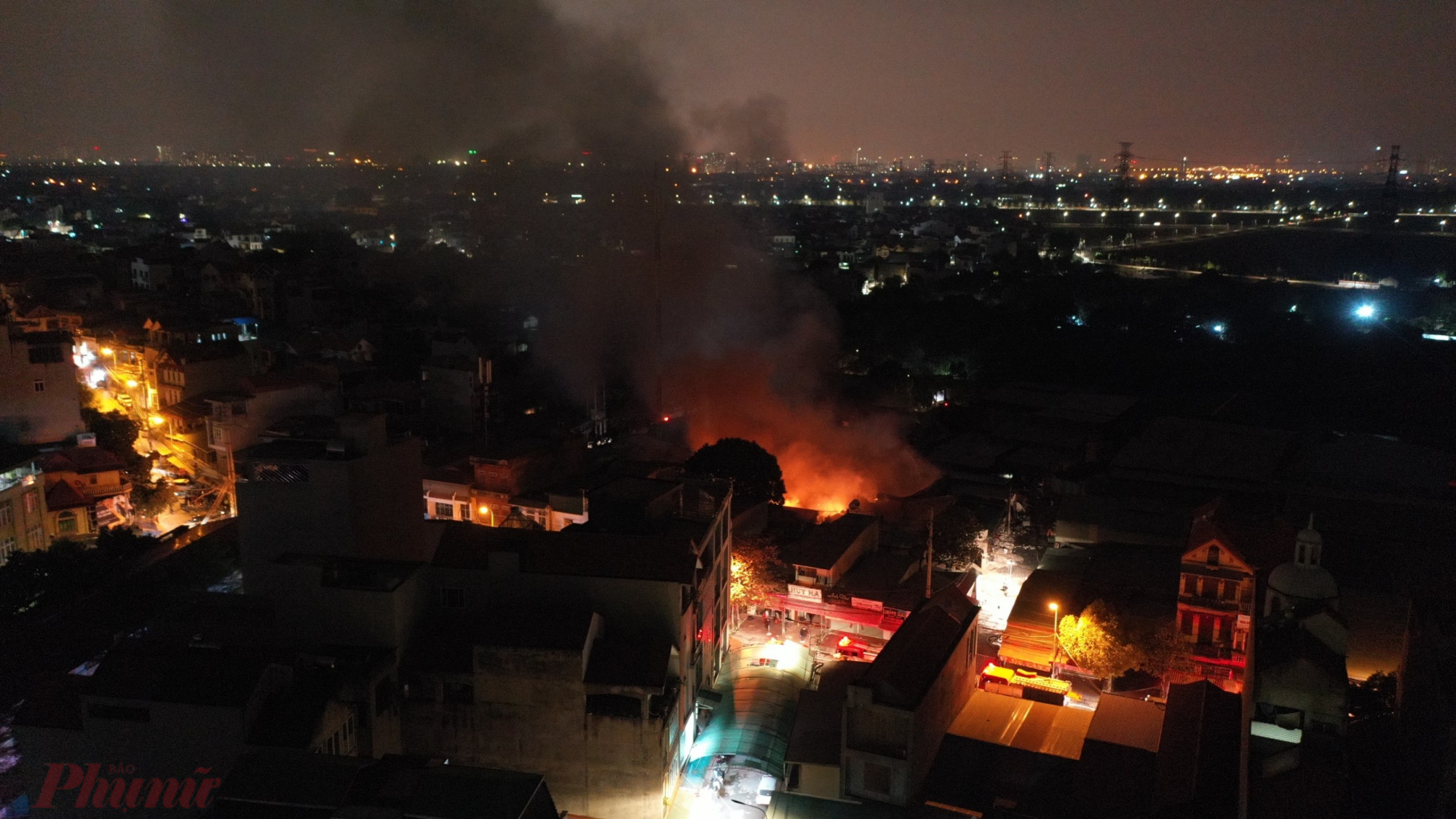  Đến 20h20, Lửa ch&aacute;y ng&ugrave;n ngụt, nung đỏ m&aacute;i t&ocirc;n nh&agrave; kho v&agrave; lan rộng ra xung quanh.