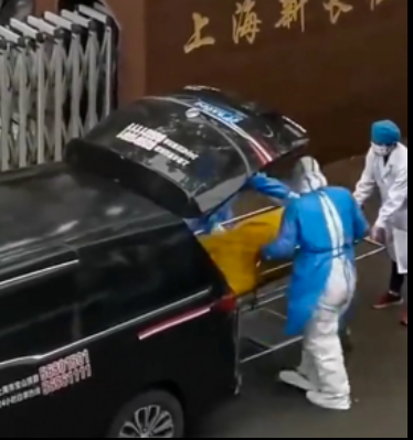 H&igrave;nh ảnh cắt từ clip cho thấy người đ&agrave;n &ocirc;ng mặc &aacute;o trắng đang cản hai nh&acirc;n vi&ecirc;n nh&agrave; x&aacute;c mặc &aacute;o xanh mang t&uacute;i đựng thi thể đi. Người đ&agrave;n &ocirc;ng n&agrave;y đ&atilde; mở t&uacute;i đựng x&aacute;c cho thấy bệnh nh&acirc;n trong t&uacute;i vẫn c&ograve;n sống