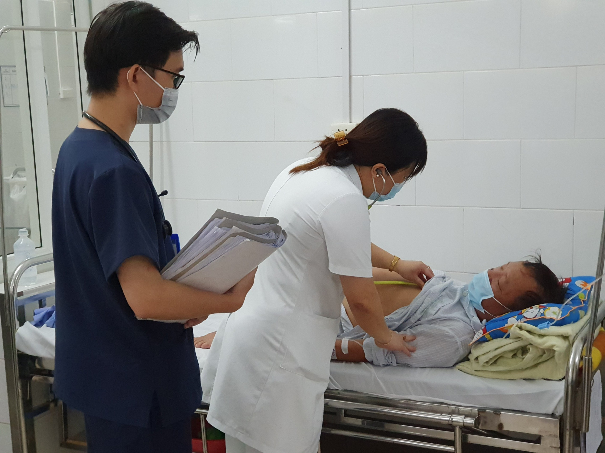 C&aacute;c b&aacute;c sĩ tại Trung t&acirc;m Bệnh nhiệt đới thăm kh&aacute;m bệnh cho bệnh nh&acirc;n đang điều trị tại khoa