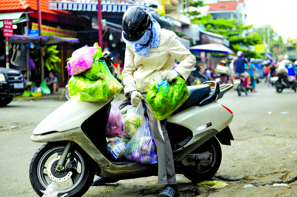 Một người d&acirc;n đi chợ truyền thống ở TP.Thủ Đức sử dụng h&agrave;ng chục t&uacute;i ni-l&ocirc;ng loại kh&oacute; ph&acirc;n hủy để đựng h&agrave;ng (ảnh chụp đầu th&aacute;ng 6/2022) ẢNH: MINH AN