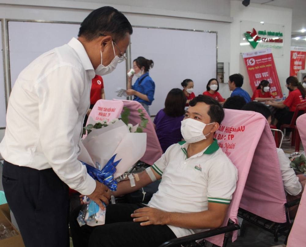 Trưởng Ban D&acirc;n vận Th&agrave;nh ủy TPHCM Nguyễn Hữu Hiệp tặng hoa cho anh Trương Vĩnh Đạt - nh&acirc;n vi&ecirc;n C&ocirc;ng ty GreenFeed tham gia hiến m&aacute;u hưởng ứng Ng&agrave;y hội Giọt hồng th&agrave;nh phố mang t&ecirc;n B&aacute;c.