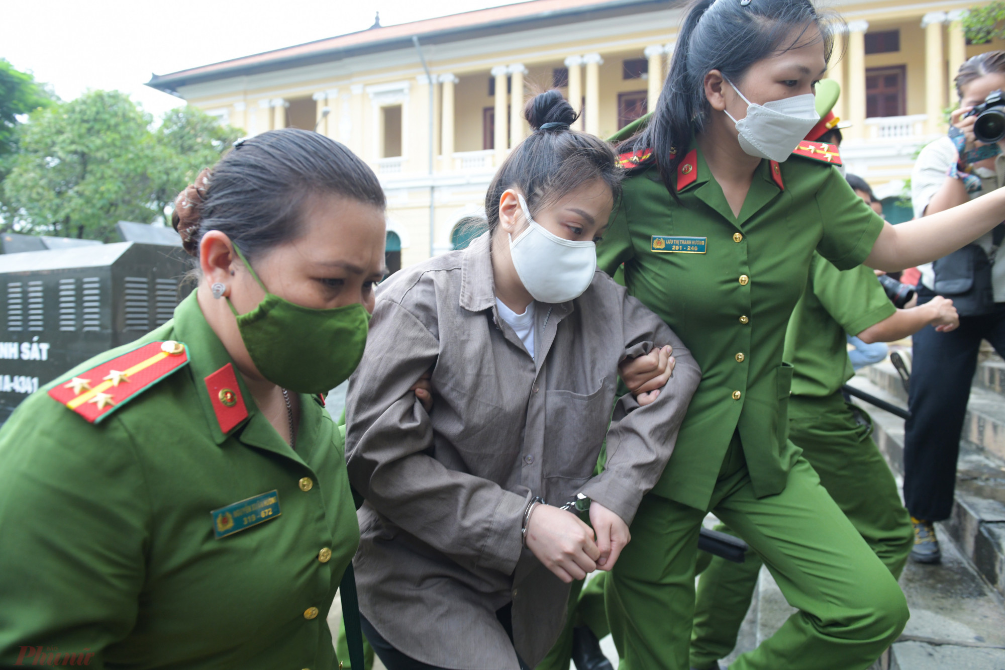 Nữ bị c&aacute;o lu&ocirc;n c&uacute;i gằm mặt xuống đất từ khi cảnh s&aacute;t đưa ra từ xe th&ugrave;ng.