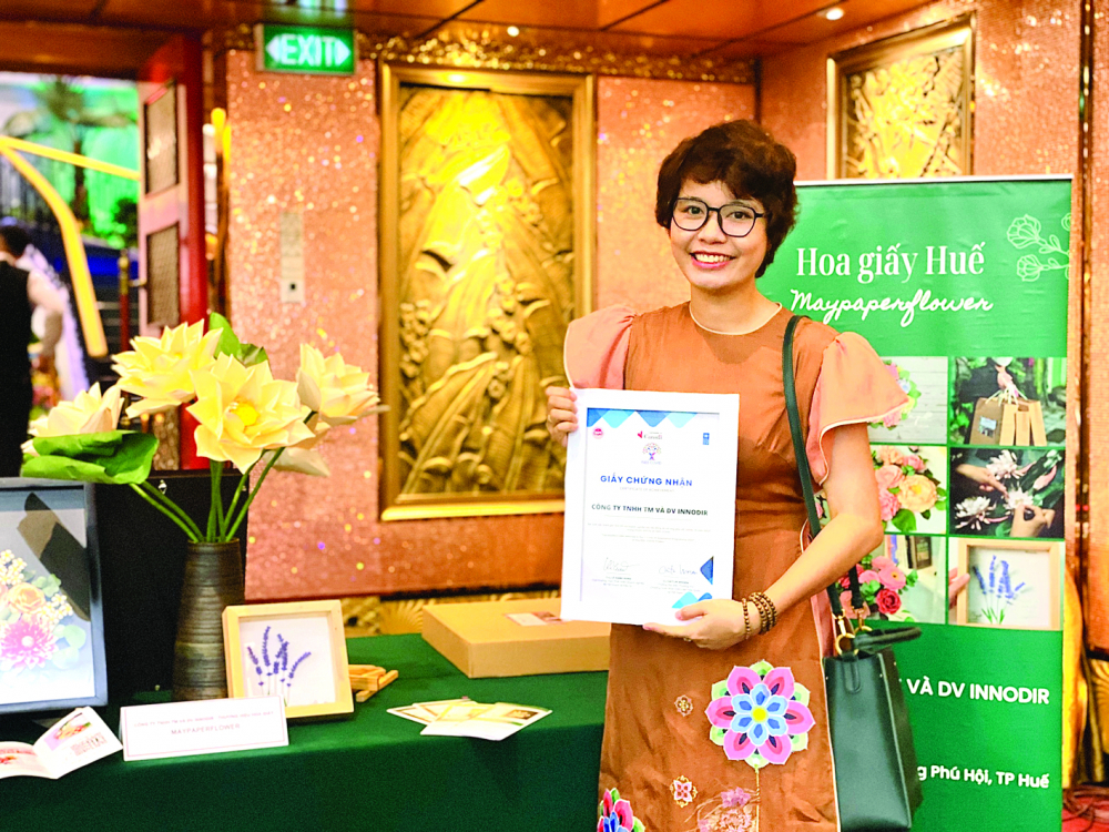 Phan Ngọc Hiếu với những sản phẩm hoa giấy do ch&iacute;nh c&ocirc; học hỏi, s&aacute;ng tạo n&ecirc;n