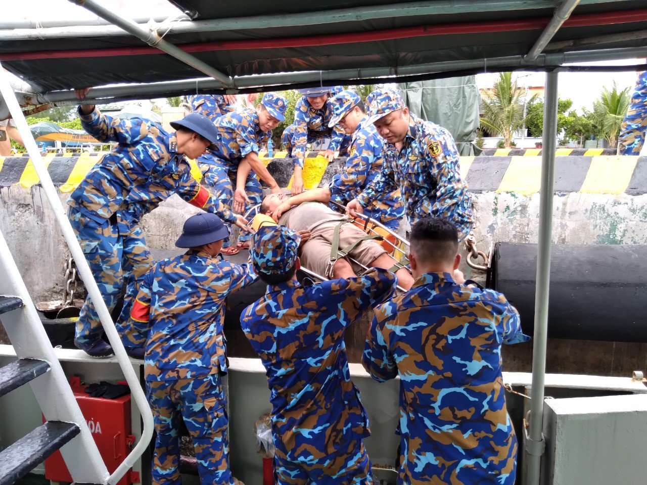 C&aacute;n bộ, chiến sĩ đảo Sinh Tồn đưa bệnh nh&acirc;n Hửu l&ecirc;n đảo cấp cứu - Ảnh: Nguyễn Nam