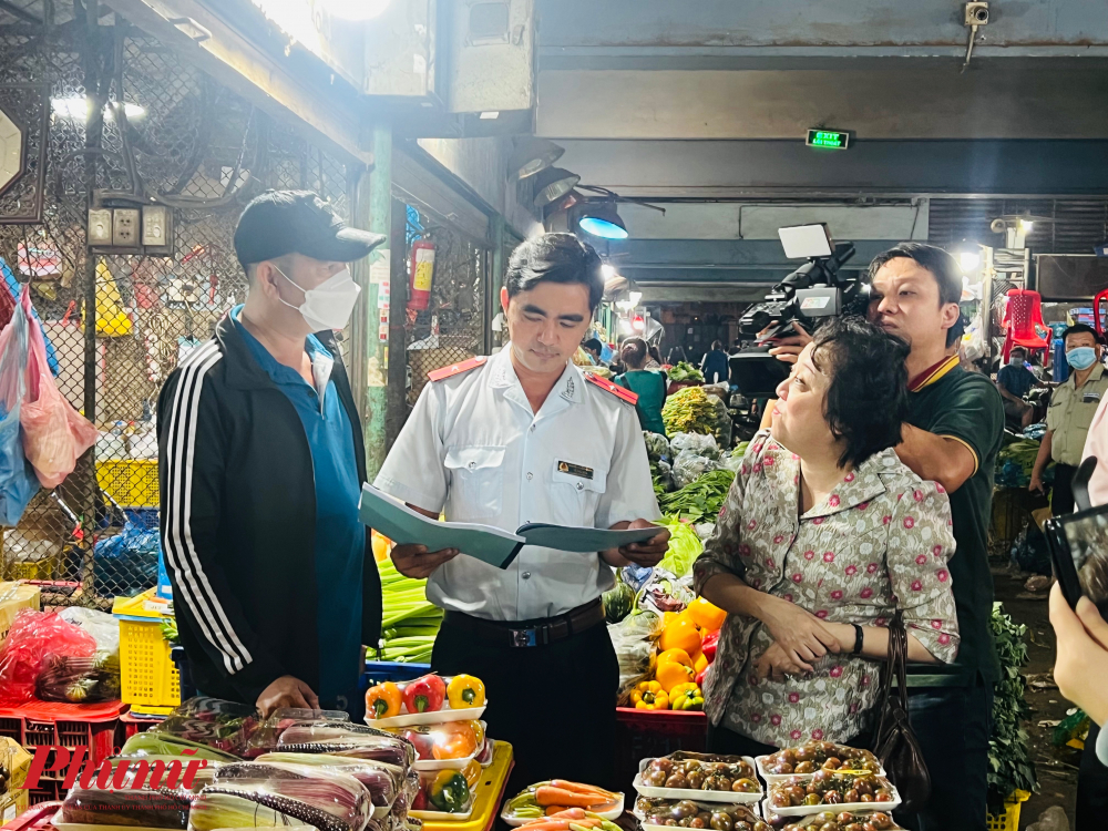 B&agrave; Phạm Kh&aacute;nh Phong Lan - Trưởng Ban quản l&yacute; ATTP TPHCM dẫn đo&agrave;n c&ocirc;ng t&aacute;c l&agrave;m việc tại c&aacute;c chợ đầu mối, n&ocirc;ng sản tr&ecirc;n địa b&agrave;n TPHCM. (Trong ảnh: Đo&agrave;n khảo s&aacute;t đến l&agrave;m việc tại một sạp rau, củ, quả trong chợ đầu mối n&ocirc;ng sản Thủ Đức).