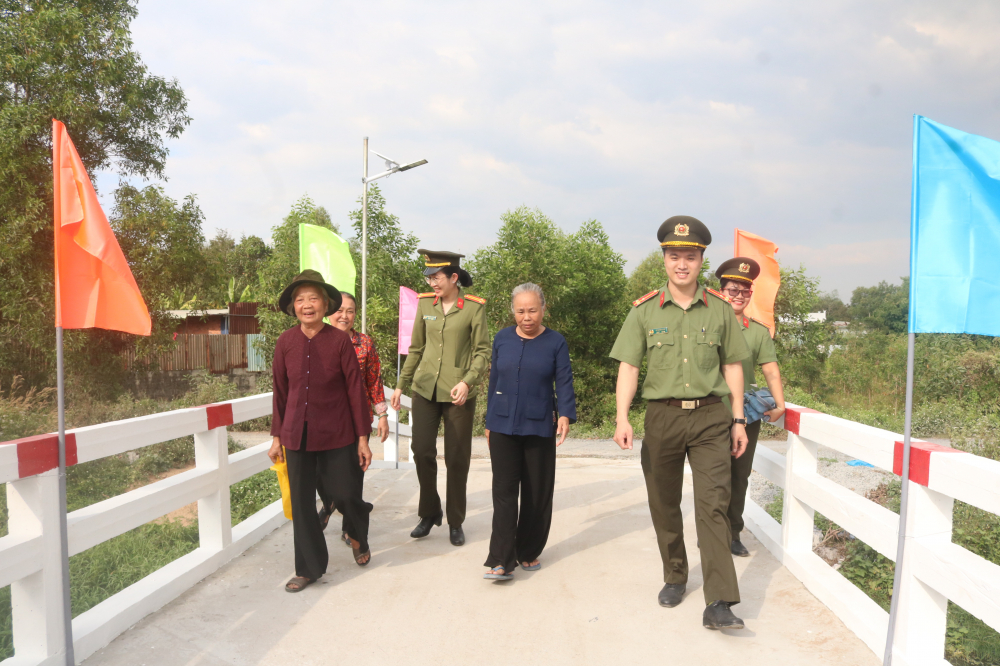 B&agrave; con địa phương c&ugrave;ng c&aacute;n bộ chiến sĩ Ph&ograve;ng Tổ chức c&aacute;n bộ C&ocirc;ng an TP.HCM c&ugrave;ng bước đi tr&ecirc;n c&acirc;y cầu mới trong niềm phấn khởi. 