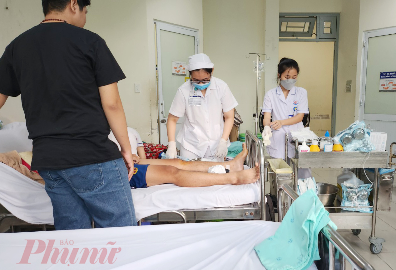 Sau khi b&aacute;c sĩ thăm kh&aacute;m, c&aacute;c chị điều dưỡng rửa vết thương cho bệnh nh&acirc;n trước khi người bệnh xuất viện