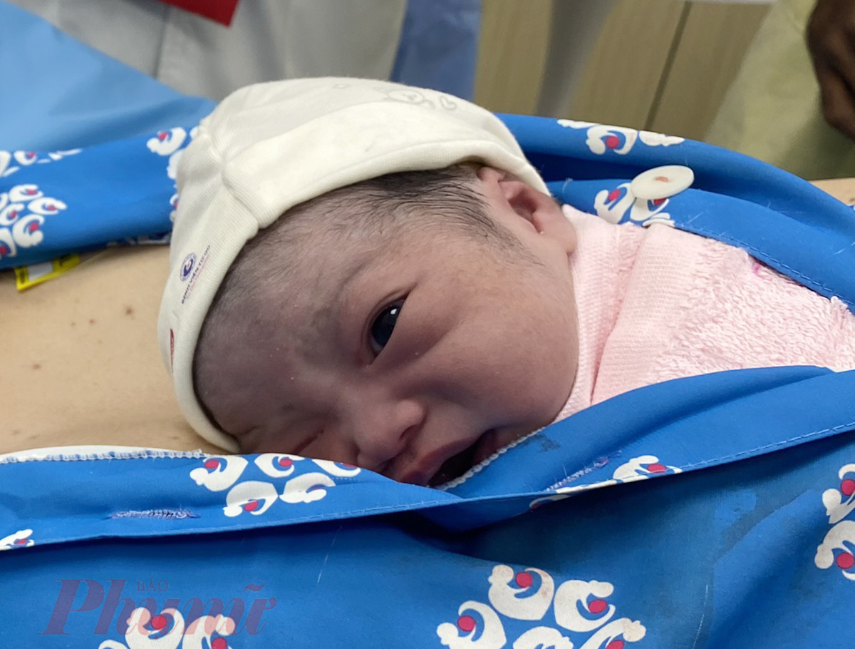 B&eacute; g&aacute;i lanh lợi vừa cảm nhận hơi ấm của mẹ, vừa nh&igrave;n quanh kh&aacute;m ph&aacute;