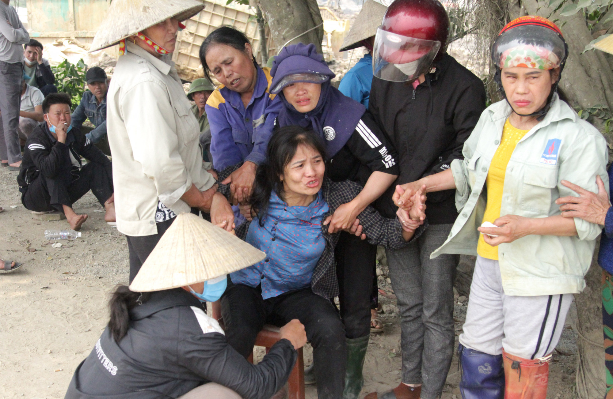 Người th&acirc;n can ngăn b&agrave; Diệu chạy đến &ocirc;m lấy quan t&agrave;i con - Ảnh: Phan Ngọc