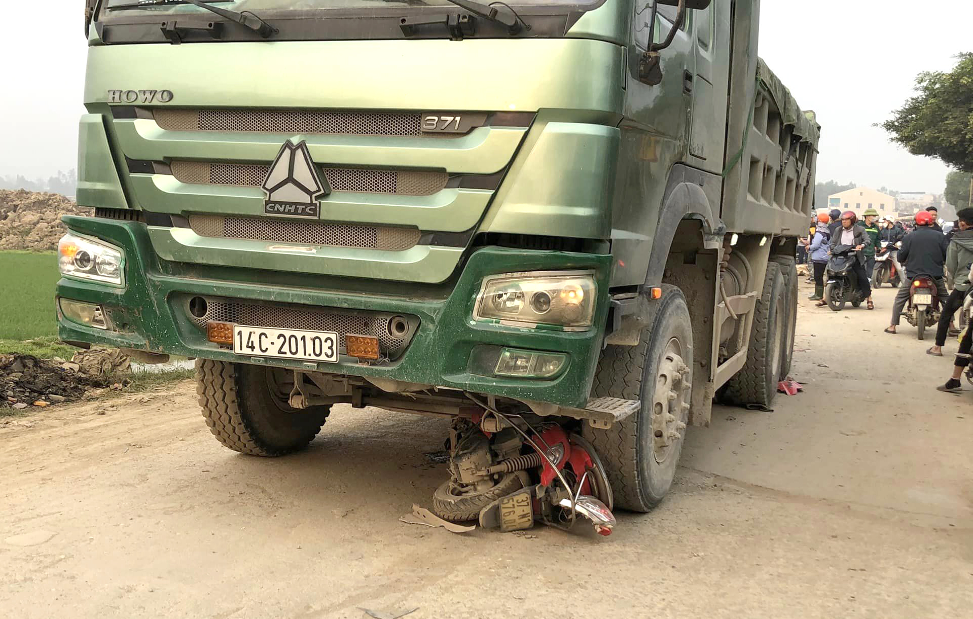 Chiếc xe m&aacute;y nằm lọt dưới gầm xe tải sau tai nạn - Ảnh: Kh&aacute;nh Trung