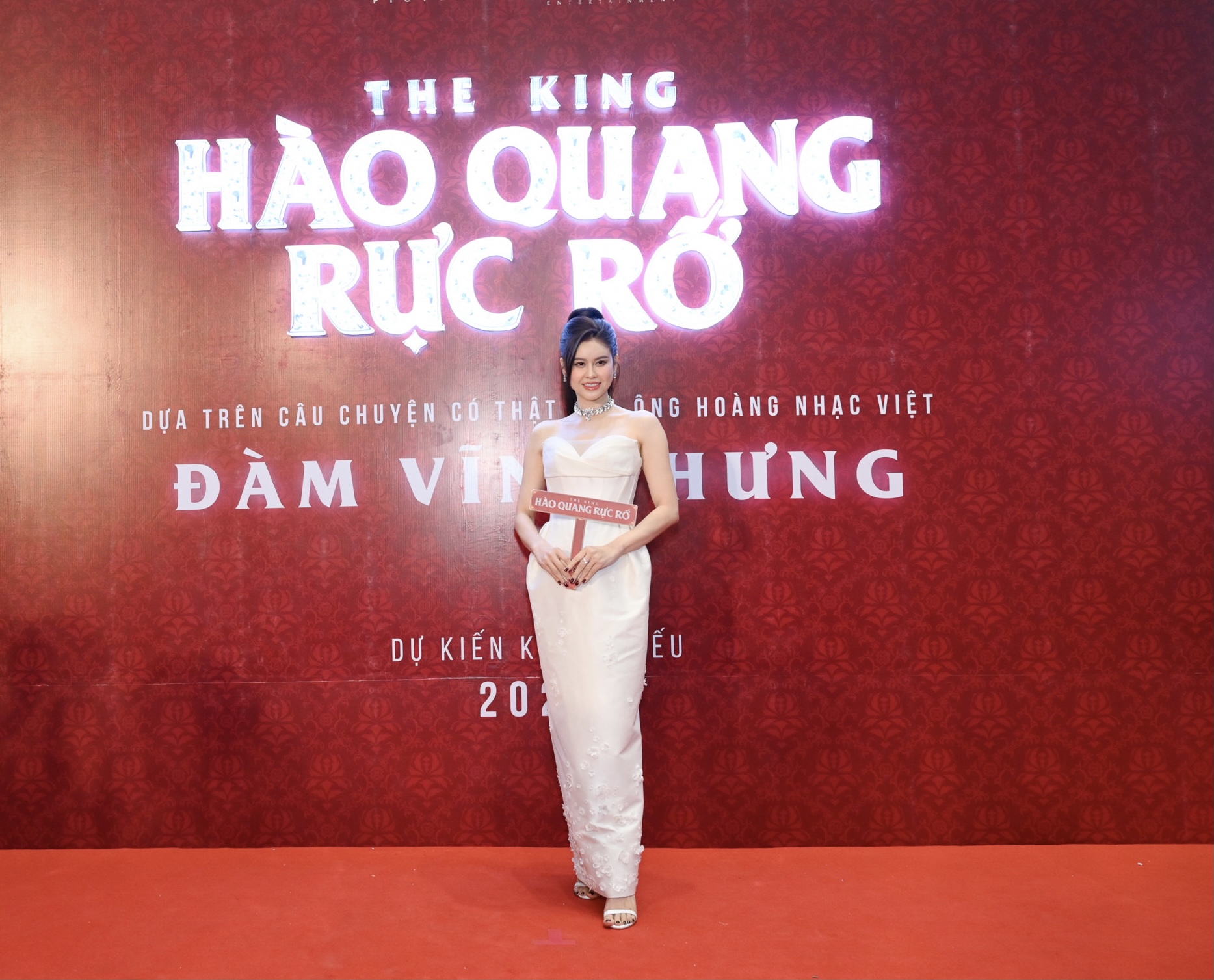 Trương Quỳnh Anh chọn bộ c&aacute;nh sắc trắng với thiết kế c&uacute;p ngực, d&aacute;ng phồng lạ mắt, đi k&egrave;m phụ kiện v&ograve;ng cổ kim loại, sandal quai mảnh ăn &yacute; với tổng thể trang phục.