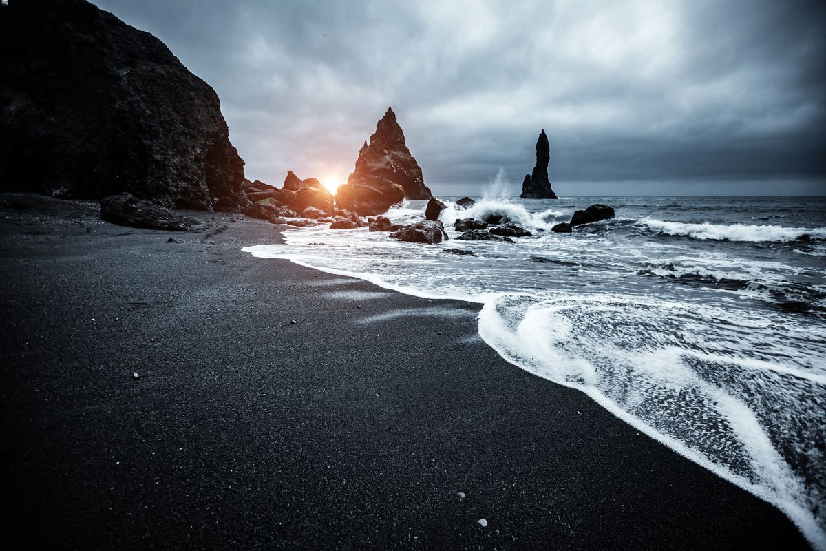 Những b&atilde;i biển c&aacute;t đen ở Iceland giống như một khung cảnh si&ecirc;u thực trong một bộ phim giả tưởng ho&agrave;nh tr&aacute;ng. C&oacute; một c&aacute;i g&igrave; đ&oacute; ảm đạm nhưng đầy m&ecirc; hoặc về những con s&oacute;ng xanh thẳm vỗ v&agrave;o b&atilde;i c&aacute;t đen như than. C&aacute;c b&atilde;i biển đặc biệt c&oacute; m&agrave;u sẫm do nguồn gốc n&uacute;i lửa của ch&uacute;ng. Dung nham bắt nguồn từ một ngọn n&uacute;i lửa kh&ocirc;ng hoạt động, chảy v&agrave;o b&atilde;i biển v&agrave; nguội đi nhanh ch&oacute;ng khi tiếp x&uacute;c với nước biển lạnh. Do qu&aacute; tr&igrave;nh nguội đi nhanh ch&oacute;ng n&agrave;y, dung nham đ&ocirc;ng đặc lại th&agrave;nh đ&aacute; bazan, sau đ&oacute; bị x&oacute;i m&ograve;n, dần dần vỡ ra th&agrave;nh c&aacute;c mảnh nhỏ hơn, cuối c&ugrave;ng tạo th&agrave;nh c&aacute;t đen.