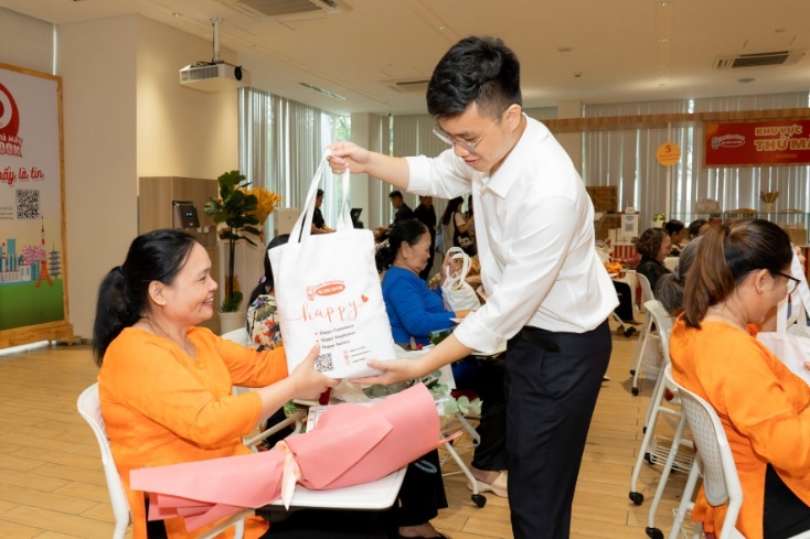 Người ti&ecirc;u d&ugrave;ng được tặng qu&agrave; khi đến tham quan nh&agrave; m&aacute;y - Ảnh: ACV