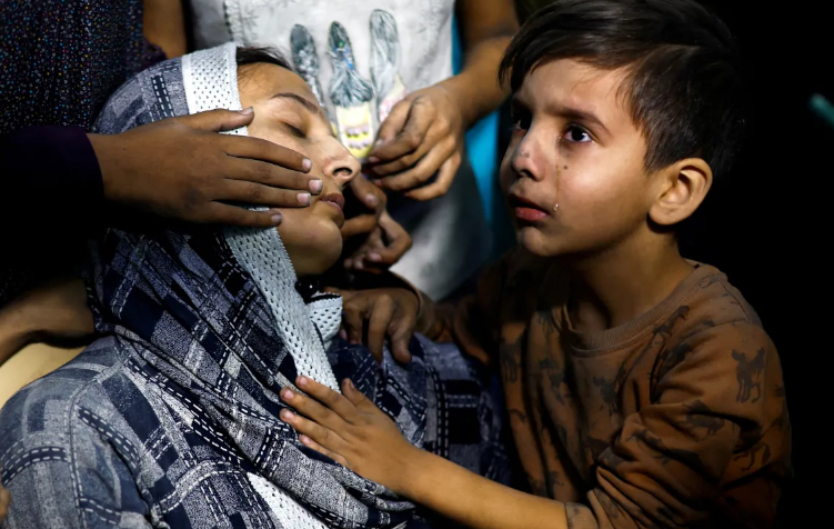 Một đứa trẻ Palestine kh&oacute;c cạnh mẹ sau khi được đưa đến bệnh viện Nasser, sau cuộc tấn c&ocirc;ng của Israel ở Khan Younis v&agrave;o ng&agrave;y 13 th&aacute;ng 11 năm 2023. [Mohammed Salem / Reuters]