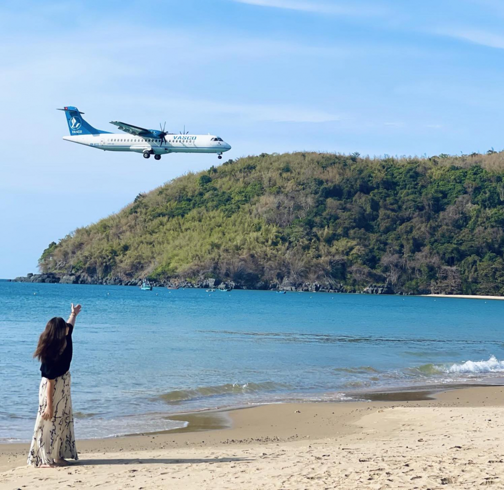Du kh&aacute;ch vừa ngắm biển, vừa chụp ảnh với m&aacute;y bay đ&aacute;p xuống s&acirc;n bay C&ocirc;n Đảo. Ảnh: Kim Dung