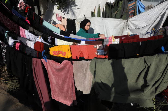 Một phụ nữ Palestine đang phơi đồ ở Khan Younis. Đối với 700.000 phụ nữ v&agrave; trẻ em g&aacute;i ở Gaza thời kỳ của họ l&agrave; khoảng thời gian đau đớn v&agrave; tủi nhục. Ảnh: Anadolu/Getty Images