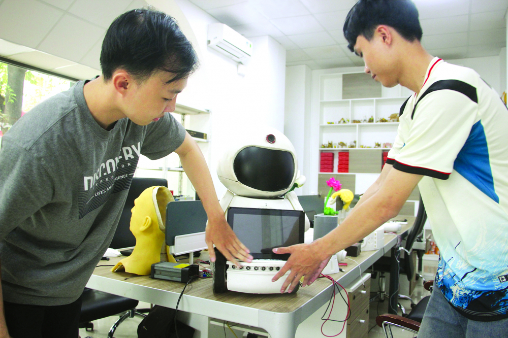 Sinh vi&ecirc;n năm thứ nhất ng&agrave;nh robot v&agrave; tr&iacute; tuệ nh&acirc;n tạo của Đại học Kinh tế TPHCM đang thử nghiệm d&ugrave;ng AI điều khiển robot ẢNH: NGUYỄN LOAN