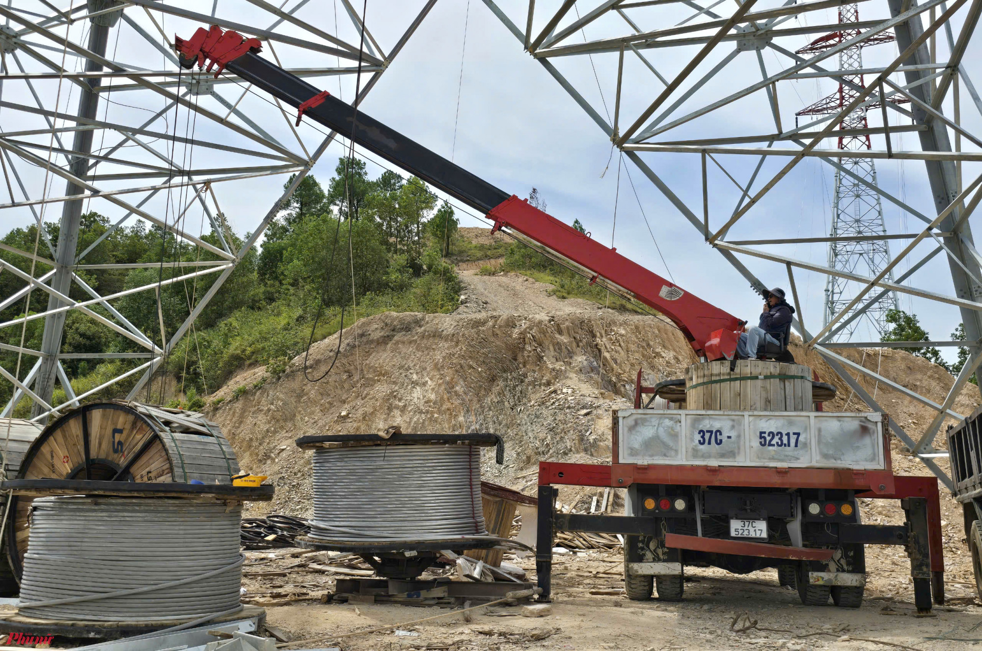 Vật tư, thiết bị được đưa đến dưới ch&acirc;n cột. Mỗi cuộn d&acirc;y dẫn c&oacute; chiều d&agrave;i 2.000-2.400m, nặng 5-6 tấn. Nhiều cột điện nằm tr&ecirc;n đỉnh n&uacute;i, bởi thế để vận chuyển thiết bị l&ecirc;n tới ch&acirc;n cột kh&aacute; vất vả.