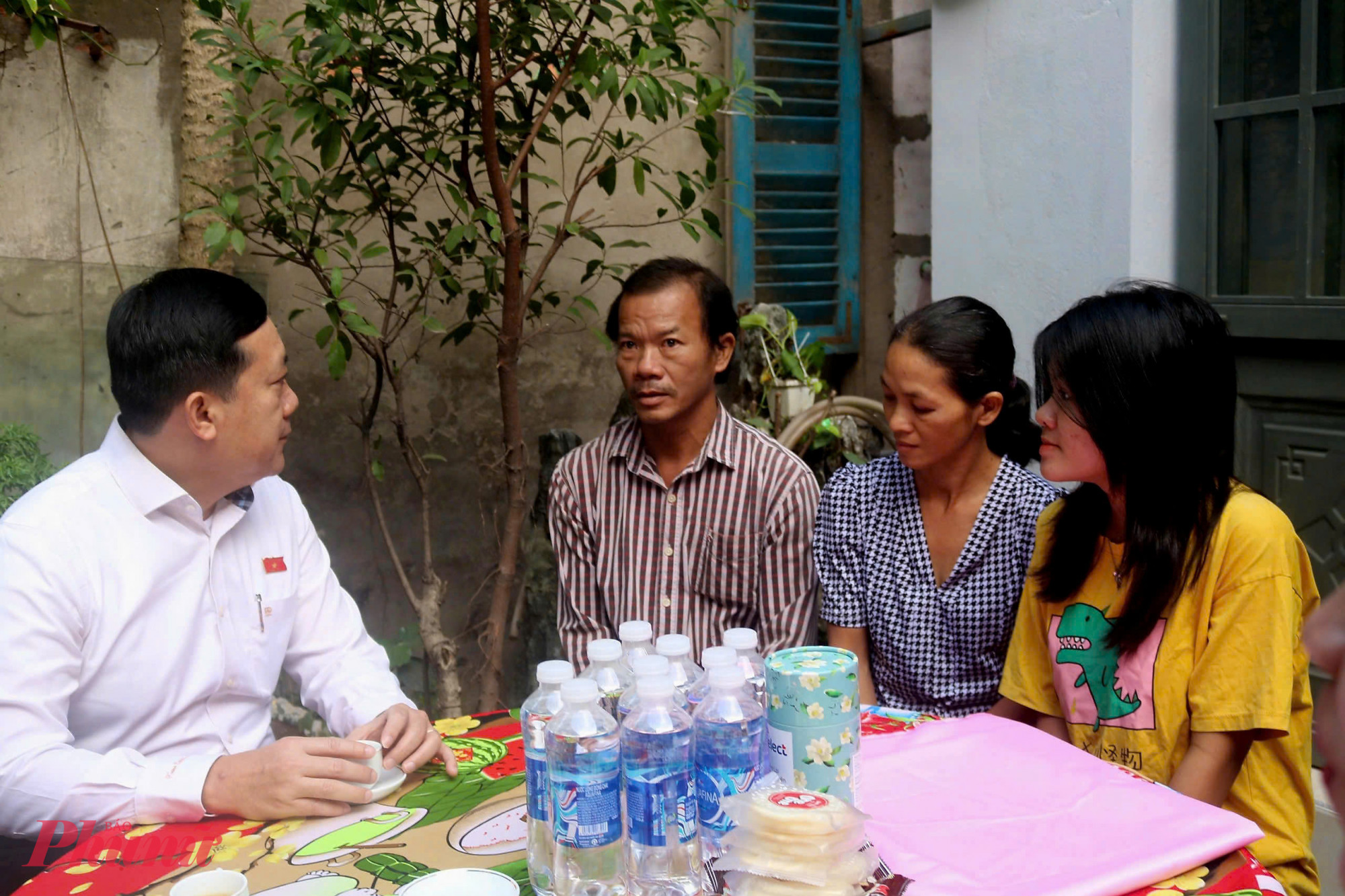 Đại biểu H&agrave; Phước Thắng (b&igrave;a tr&aacute;i) động vi&ecirc;n gia đ&igrave;nh chị Hoa nỗ lực vượt qua kh&oacute; khăn, chăm lo c&aacute;c con ăn học.