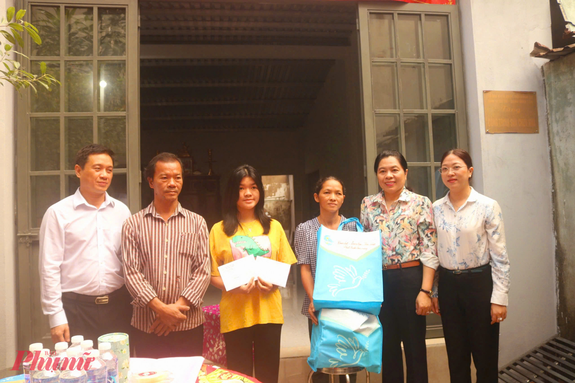 B&agrave; Nguyễn Trần Phượng Tr&acirc;n (thứ 2, từ phải qua) &ndash; Chủ tịch Hội LHPN TPHCM &ndash; trao qu&agrave; cho gia đ&igrave;nh chị Hoa. 