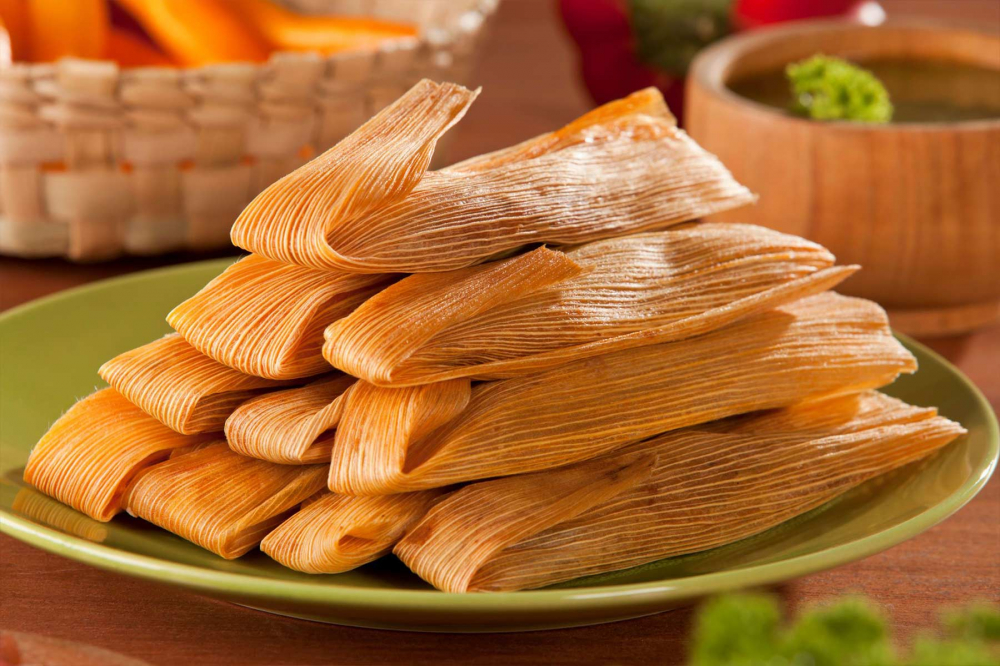 Tamales Cusque&ntilde;os l&agrave; một m&oacute;n ăn truyền thống của v&ugrave;ng Cusco, Peru, l&agrave;m từ bột ng&ocirc; (masa) trộn với nước luộc thịt v&agrave; mỡ, g&oacute;i trong l&aacute; chuối hoặc l&aacute; ng&ocirc;, rồi hấp ch&iacute;n. Nh&acirc;n thường gồm thịt g&agrave;, lợn hoặc b&ograve;, k&egrave;m gia vị địa phương như ớt aj&iacute; panca, trứng luộc, v&agrave; &ocirc; liu. Đ&acirc;y l&agrave; m&oacute;n ăn phổ biến trong lễ hội v&agrave; bữa s&aacute;ng, mang đậm n&eacute;t văn h&oacute;a ẩm thực v&ugrave;ng Andes.