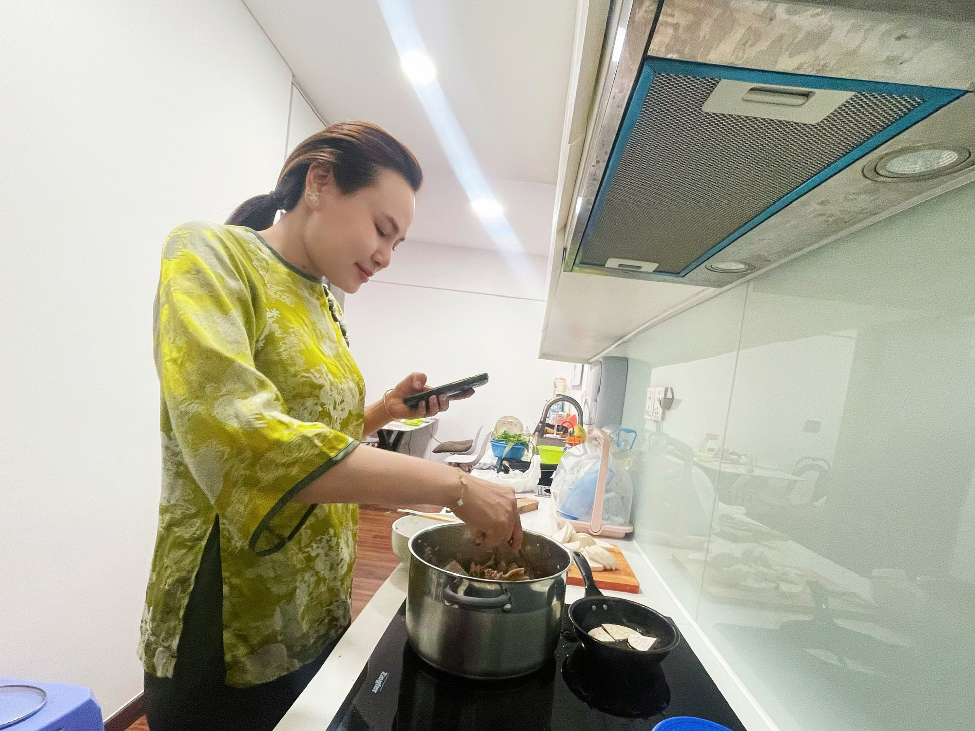 Chị Xu&acirc;n Đ&agrave;o trổ t&agrave;i nấu ăn theo hướng dẫn tr&ecirc;n mạng x&atilde; hội để chi&ecirc;u đ&atilde;i gia đ&igrave;nh - Ảnh: Nh&atilde; Ch&acirc;n