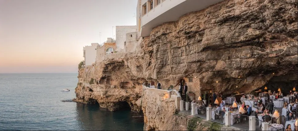 Ăn tối trong hang động ở &Yacute;: Grotta Palazzese l&agrave; một hang động đ&aacute; v&ocirc;i ven biển nh&igrave;n ra biển Adriatic ở Polignano Mare, &Yacute;. Trong hang c&oacute; nh&agrave; h&agrave;ng Ristorante Grotta Palazzese v&agrave; phải đặt b&agrave;n trước h&agrave;ng th&aacute;ng. Nh&agrave; h&agrave;ng n&agrave;y nổi tiếng với c&aacute;c m&oacute;n hải sản đi k&egrave;m với rượu vang từ v&ugrave;ng Puglia của &Yacute;. Ảnh tr&ecirc;n: Grotta Palazzese ở Polignano a Mare, &Yacute;- Ảnh: Getty
