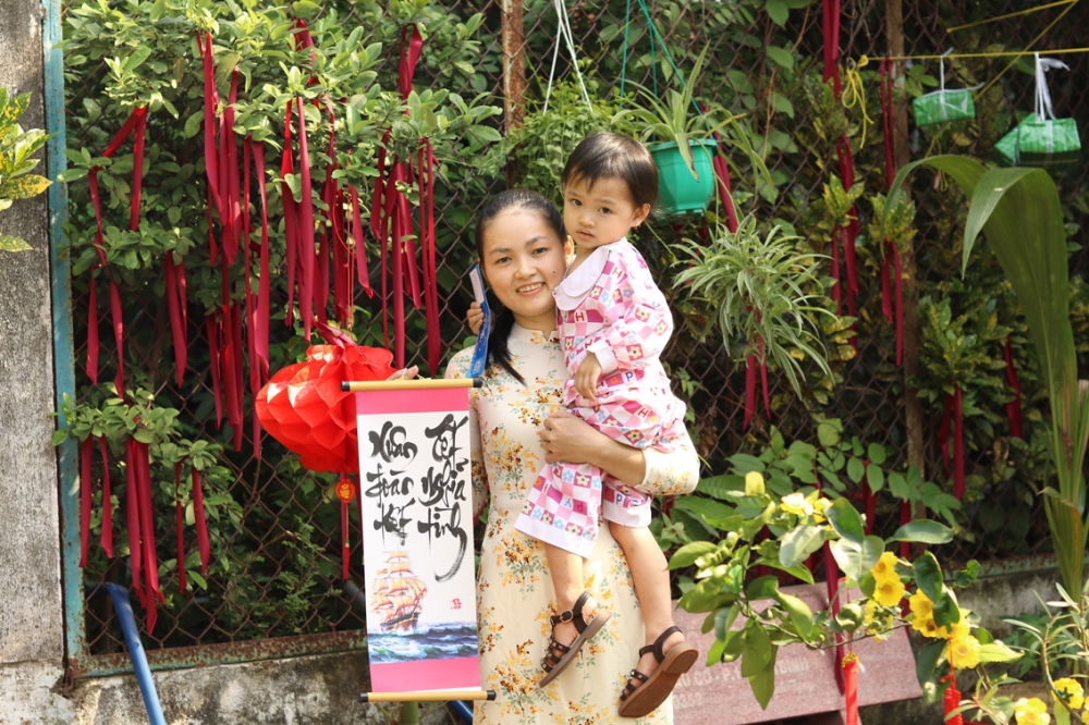 Chị L&ecirc; Thị Mỹ Hiền v&agrave; con g&aacute;i trong niềm vui được chăm lo v&agrave; được tặng v&eacute; xe về qu&ecirc; đ&oacute;n tết