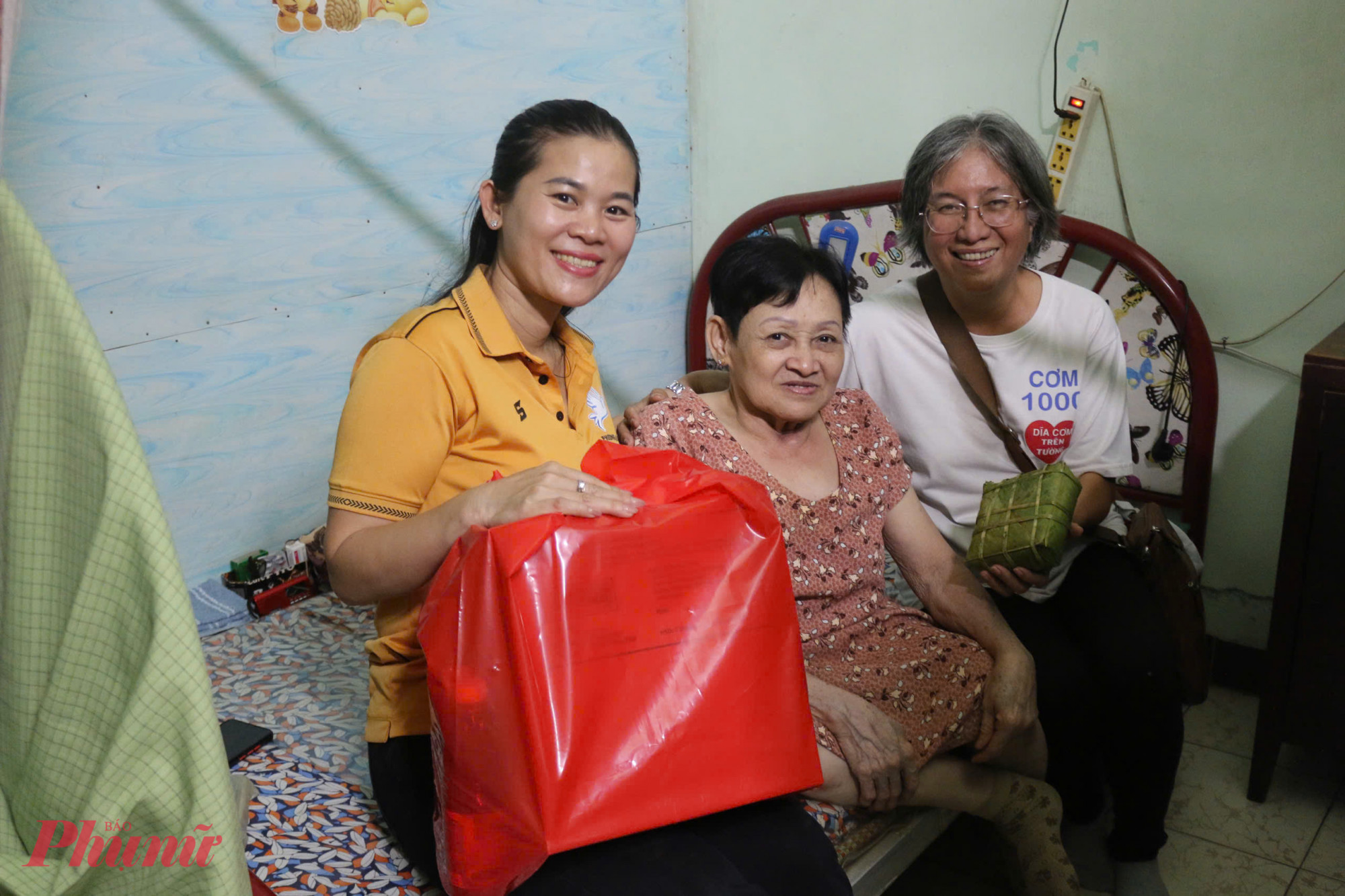 B&agrave; Trần Thị Thanh Thủy - Chủ tịch Hội LHPN phường 14 (b&igrave;a tr&aacute;i) v&agrave; c&aacute;c t&igrave;nh nguyện vi&ecirc;n đem b&aacute;nh chưng v&agrave; qu&agrave; tết trao cho hộ gia đ&igrave;nh b&agrave; Trần Thị Tư (64 tuổi, khu phố 10). L&agrave; phụ nữ neo đơn v&agrave; khuyết tật đ&atilde; nhiều năm. Khi cầm tr&ecirc;n tay chiếc b&aacute;nh chưng c&ugrave;ng phần qu&agrave; Tết, b&agrave; kh&ocirc;ng giấu được niềm vui:Vậy l&agrave; đủ hương vị Tết rồi! Nếu c&aacute;c c&ocirc; kh&ocirc;ng đến tặng, t&ocirc;i cũng kh&ocirc;ng nghĩ m&igrave;nh sẽ mua những thứ n&agrave;y để ăn ng&agrave;y Tết. Vui lắm, hạnh ph&uacute;c lắm, b&agrave; Tư x&uacute;c động chia sẻ.   