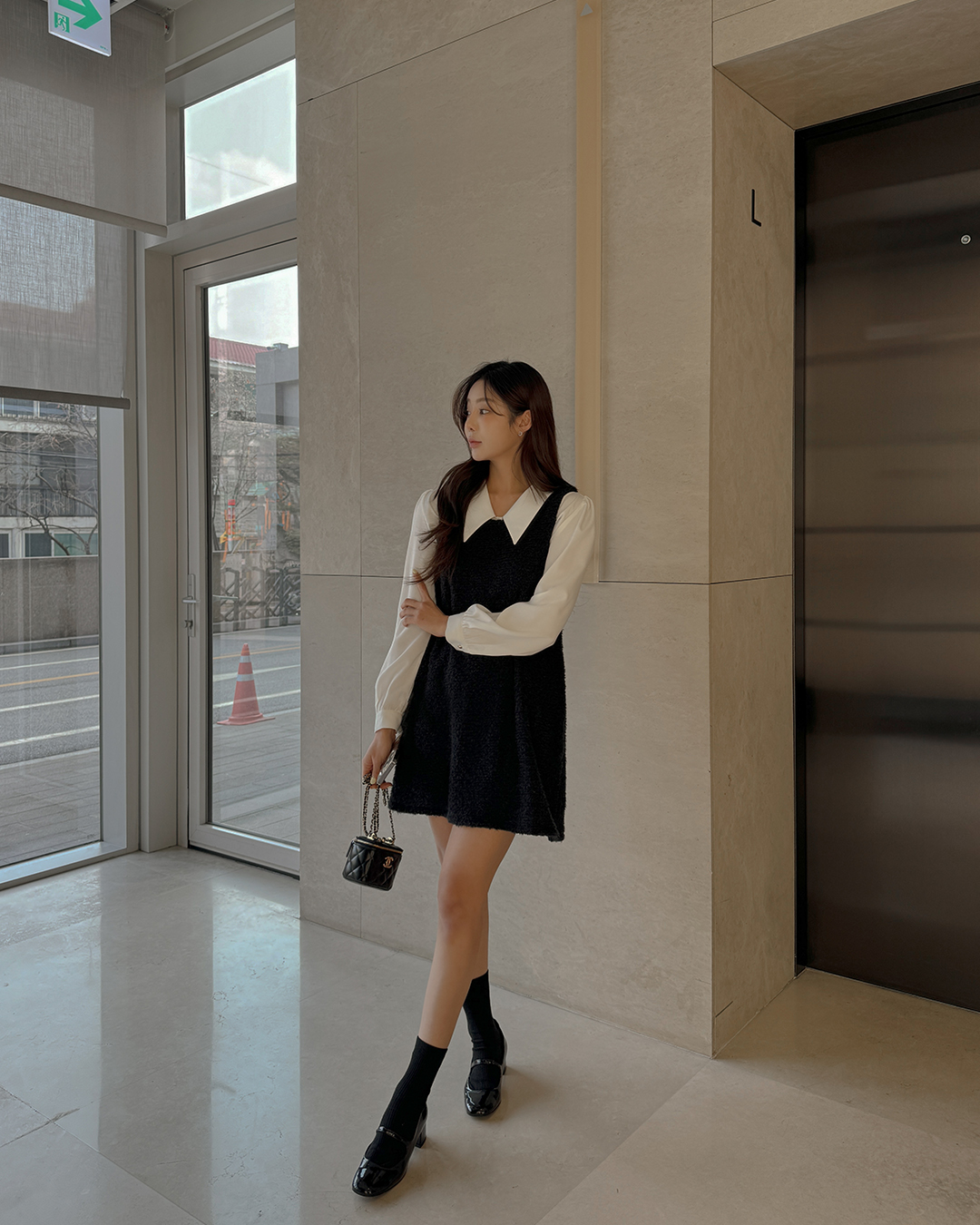 C&ocirc;ng thức &aacute;o blouse trắng v&agrave; v&aacute;y gile đen kh&ocirc;ng bao giờ lỗi mốt. Thiết kế v&aacute;y d&aacute;ng ngắn đ&atilde; mang đến hiệu quả t&ocirc;n d&aacute;ng cao r&aacute;o, đồng thời gi&uacute;p vẻ ngo&agrave;i th&ecirc;m ngọt ng&agrave;o, trẻ trung. Đ&ocirc;i gi&agrave;y Mary Jane nữ t&iacute;nh đ&atilde; gi&uacute;p ho&agrave;n thiện set v&aacute;y s&agrave;nh điệu.