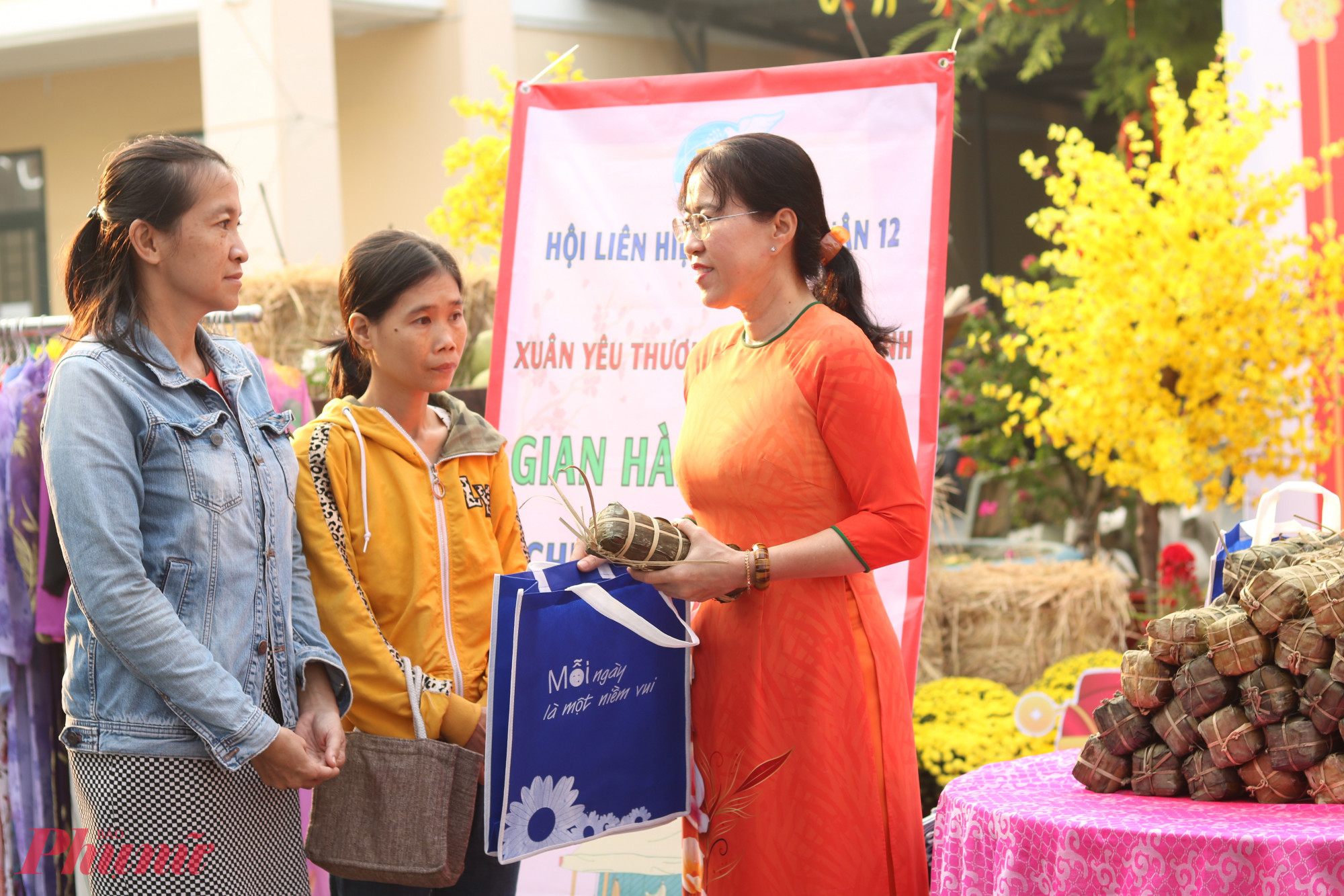 B&agrave; Trương Nhựt Thẫm (b&igrave;a phải) &ndash; Chủ tịch Hội LHPN quận 12 &ndash; trao qu&agrave;, động vi&ecirc;n chị Đặng Thị Kim Oanh (giữa) v&agrave; c&aacute;c chị em được hội chăm lo v&agrave;o s&aacute;ng 21/1. 
