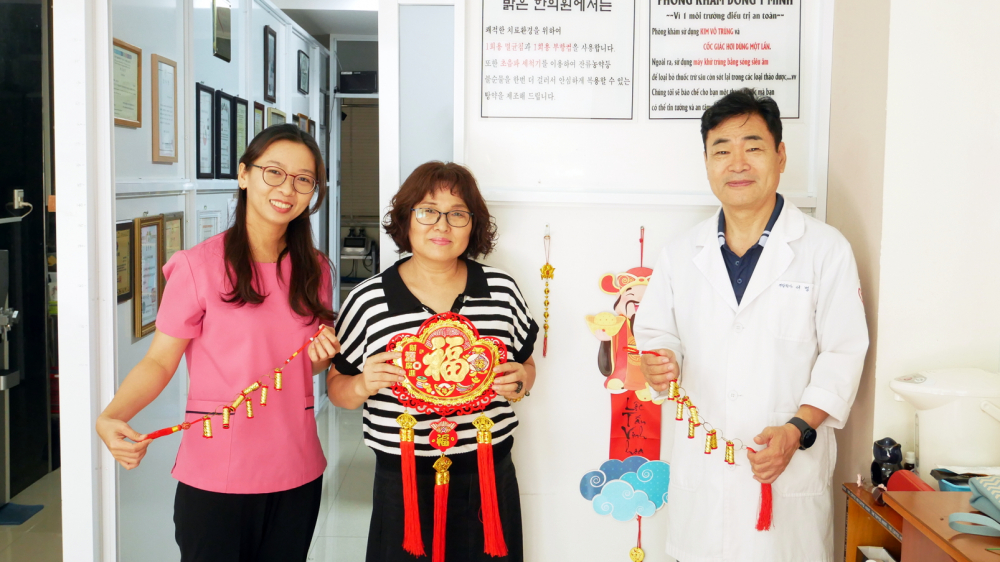 Tiến sĩ Lee Byung Geun (b&igrave;a phải) v&agrave; vợ (giữa) trang tr&iacute; nh&agrave; cửa chuẩn bị đ&oacute;n tết - ẢNH: THU L&Ecirc;