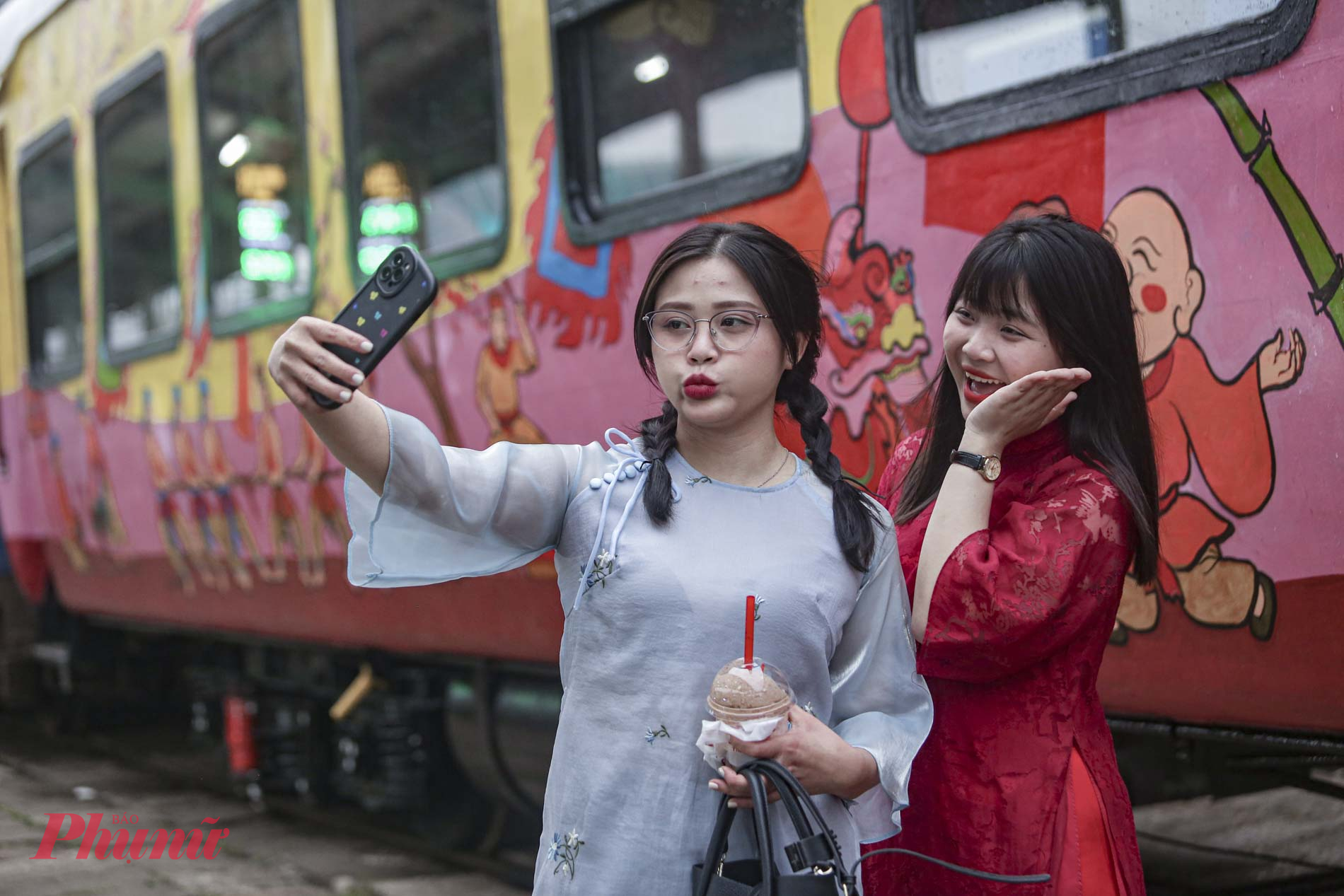 Nhiều bạn trẻ th&iacute;ch th&uacute; check-in c&ugrave;ng hai t&ograve;a t&agrave;u ngập tr&agrave;n sắc xu&acirc;n.