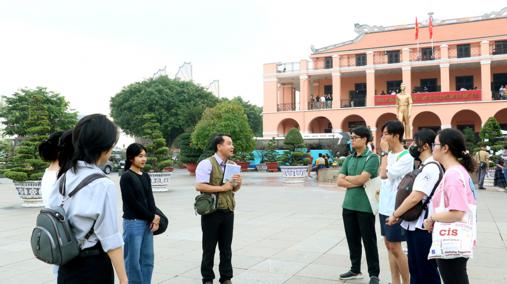 Thầy Nguyễn Tuấn Anh (người cầm s&aacute;ch) c&ugrave;ng học tr&ograve; tham quan bến Nh&agrave; Rồng - ẢNH: TRANG THƯ