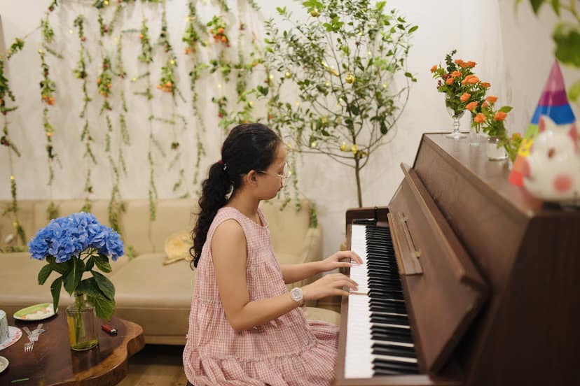 Con g&aacute;i đ&aacute;nh đ&agrave;n trong ng&agrave;y sinh nhật bố, ph&iacute;a sau l&agrave; bức tường được trang tr&iacute; từ hoa l&aacute;