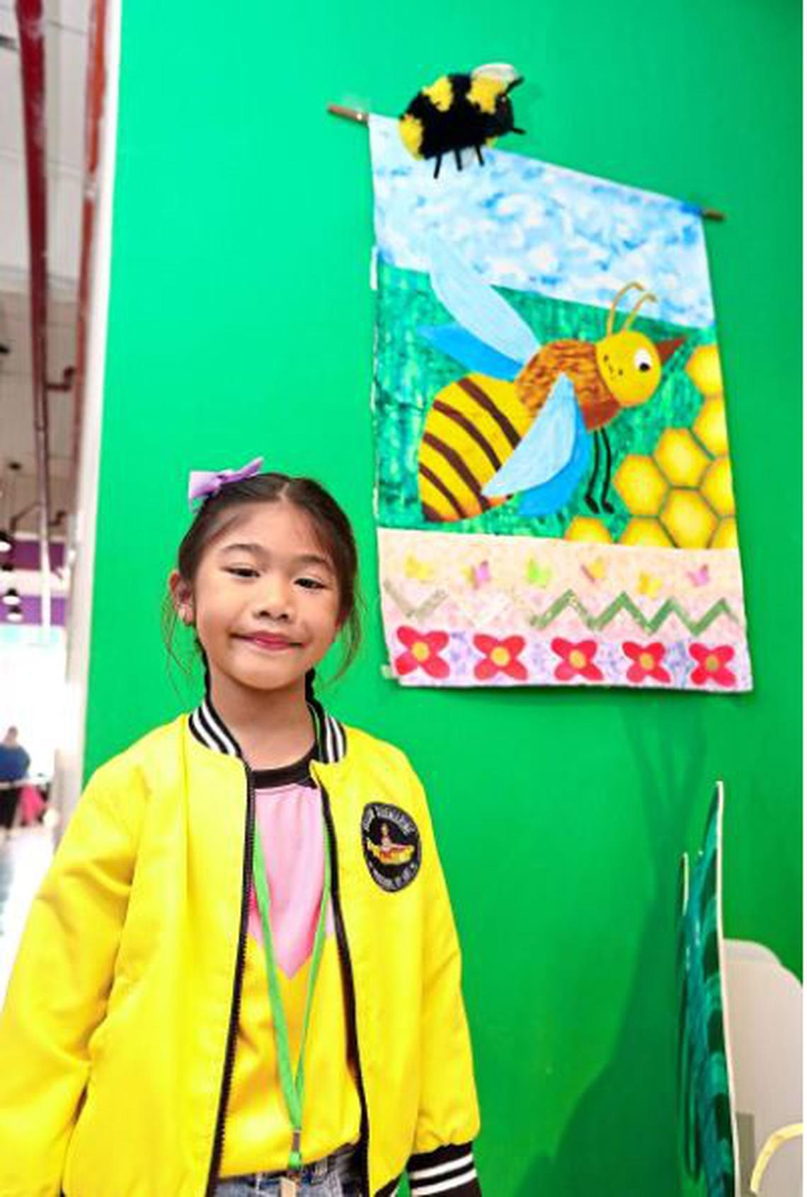 Sarah Ziyaa Mohd Syukran tự h&agrave;o đứng cạnh t&aacute;c phẩm nghệ thuật của m&igrave;nh tại Bảo t&agrave;ng Khoa học, Nghệ thuật v&agrave; Đổi mới d&agrave;nh cho Trẻ em - Ảnh: THE STAR/ASIA NEWS NETWORK