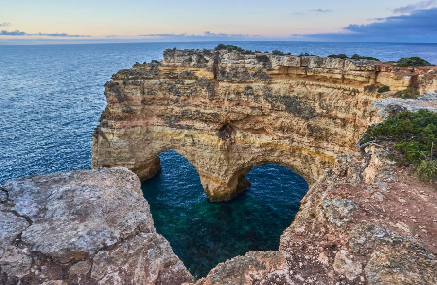 V&aacute;ch đ&aacute; Praia da Marinha, Bồ Đ&agrave;o Nha. Dọc theo bờ biển Algarve, c&oacute; những tảng đ&aacute; nh&ocirc; l&ecirc;n tr&ecirc;n mặt nước tạo th&agrave;nh h&igrave;nh tr&aacute;i tim n&ecirc;n l&agrave; điểm đến kh&ocirc;ng bỏ lỡ của t&igrave;nh nh&acirc;n. Với những v&aacute;ch đ&aacute; tuyệt đẹp v&agrave; l&agrave;n nước tĩnh lặng để bơi, Praia da Marinha l&agrave; một trong những nơi được y&ecirc;u th&iacute;ch khi đến Bồ Đ&agrave;o Nha. Ảnh tr&ecirc;n: B&igrave;nh minh tr&ecirc;n v&aacute;ch đ&aacute; Praia da Marinha dọc theo bờ biển Algarve nổi tiếng ở miền Nam Bồ Đ&agrave;o Nha - Ảnh: GETTY