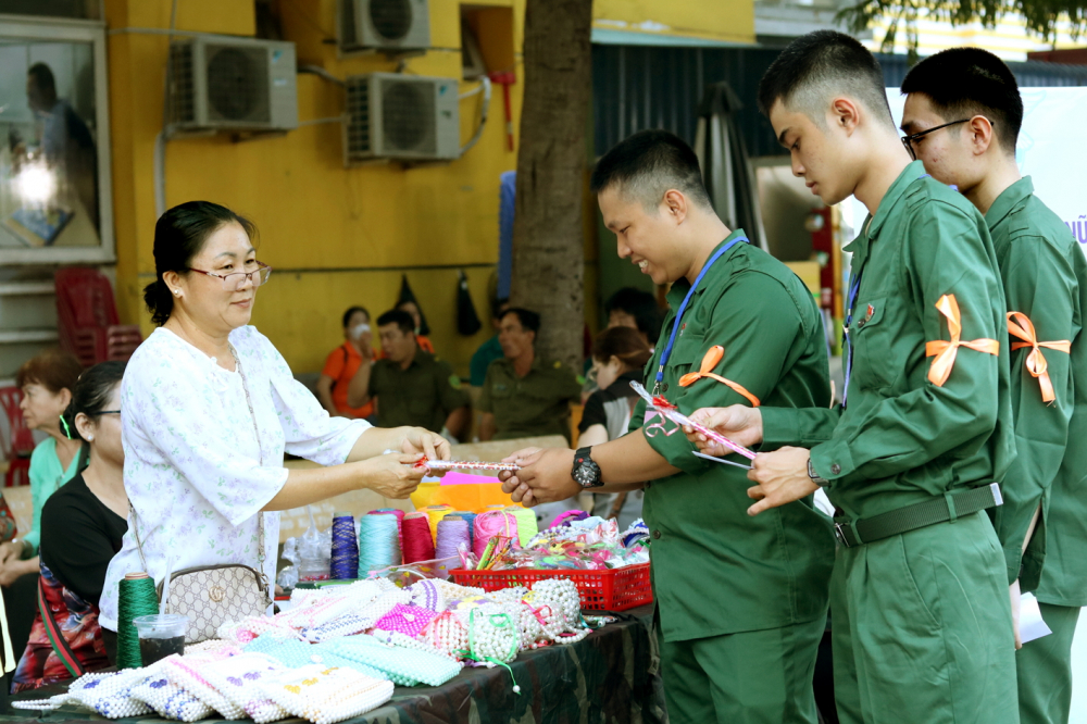 T&acirc;n binh lựa chọn những m&oacute;n qu&agrave; lưu niệm tại gian h&agrave;ng qu&agrave; lưu niệm do Hội LHPN quận B&igrave;nh T&acirc;n tổ chức - ẢNH: MẪN NHI