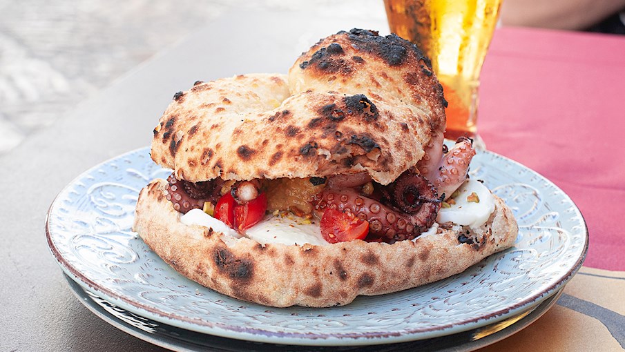 &Yacute; Panino col polpo l&agrave; một loại b&aacute;nh sandwich truyền thống c&oacute; nguồn gốc từ v&ugrave;ng Bari. Loại b&aacute;nh sandwich đơn giản n&agrave;y được l&agrave;m từ sự kết hợp của bạch tuộc, b&aacute;nh m&igrave; cuộn, dầu &ocirc; liu, rau m&ugrave;i t&acirc;y, muối v&agrave; hạt ti&ecirc;u đen. Bạch tuộc được rửa sạch, phết dầu &ocirc; liu v&agrave; nướng chậm tr&ecirc;n than hồng trong khi được phết hỗn hợp dầu &ocirc; liu, muối, hạt ti&ecirc;u v&agrave; rau m&ugrave;i t&acirc;y trong khi nấu.  Sau khi ho&agrave;n th&agrave;nh, bạch tuộc được đặt v&agrave;o ổ b&aacute;nh m&igrave; chẻ đ&ocirc;i, v&agrave; nước sốt được rưới l&ecirc;n tr&ecirc;n bạch tuộc. Loại b&aacute;nh sandwich ngon n&agrave;y thường thấy trong c&aacute;c lễ hội Apulia v&agrave; thường c&oacute; thể mua ở c&aacute;c quầy h&agrave;ng ven đường.