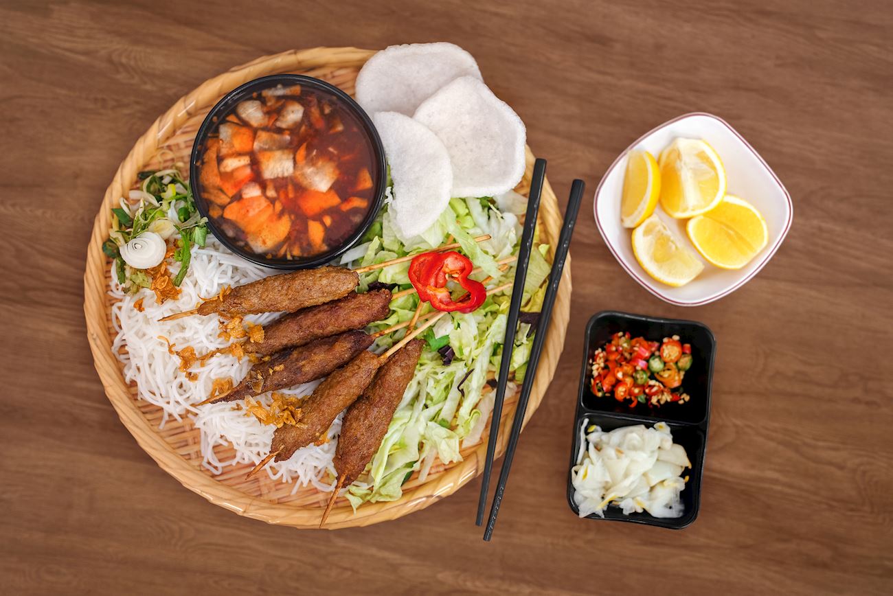 Nem lụi l&agrave; m&oacute;n ăn truyền thống c&oacute; nguồn gốc từ Huế. M&oacute;n ăn bao gồm thịt heo xay ướp gia vị rồi xi&ecirc;n qua c&acirc;y sả đem nướng l&ecirc;n. Nem lụi ăn c&ugrave;ng với rau sống, b&uacute;n, b&aacute;nh tr&aacute;ng chấm trong nước sốt đậu phộng, nước mắmchua ngọt hoặc mắm n&ecirc;m Huế - Ảnh: TasteAtlas