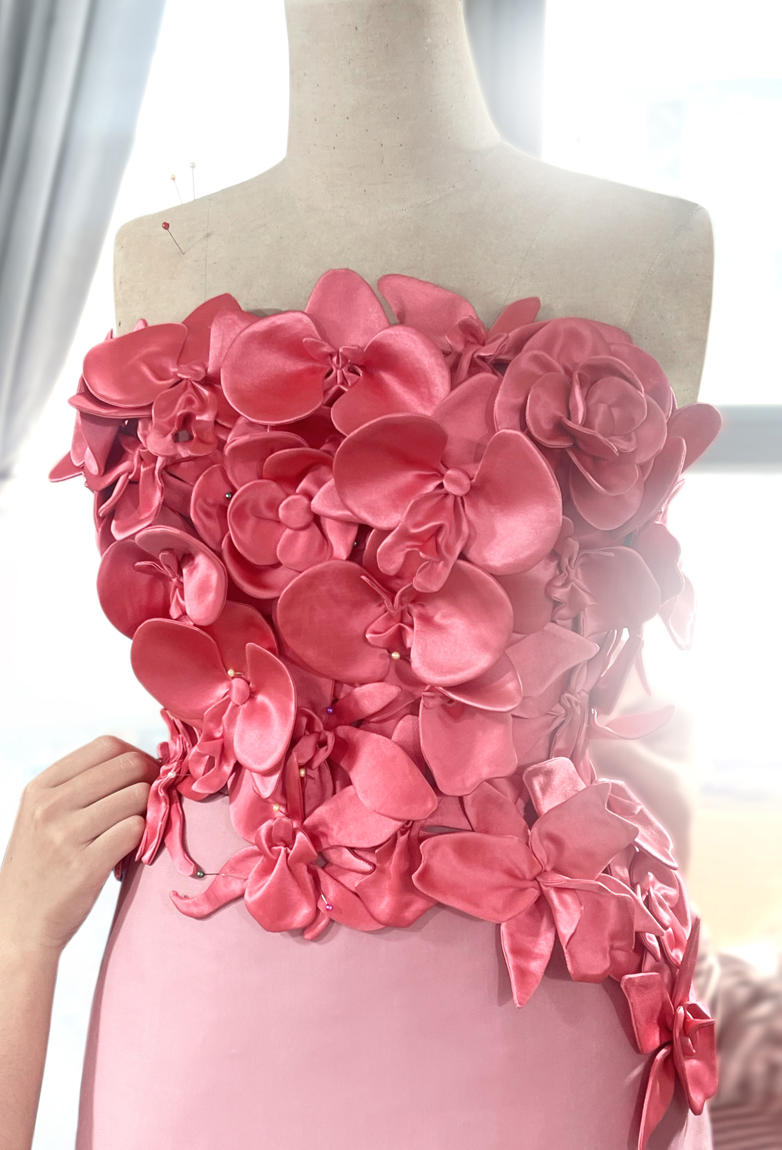 Được biết, thiết kế được l&agrave; thủ c&ocirc;ng từ chất liệu cao cấp satin silk v&agrave; mất h&agrave;ng trăm tiếng đồng hồ để ho&agrave;n thiện. Nh&agrave; thiết kế Trần H&ugrave;ng cho biết: &ldquo;Sau khi ra mắt th&agrave;nh c&ocirc;ng show diễn Xu&acirc;n H&egrave; 2025 tại London Fashion Week v&agrave;o năm ngo&aacute;i, anh nhận được lời khen từ team stylist của Ariana Grande v&agrave; đặt h&agrave;ng thiết kế hoa lan, thực hiện ri&ecirc;ng cho nữ ca sĩ.