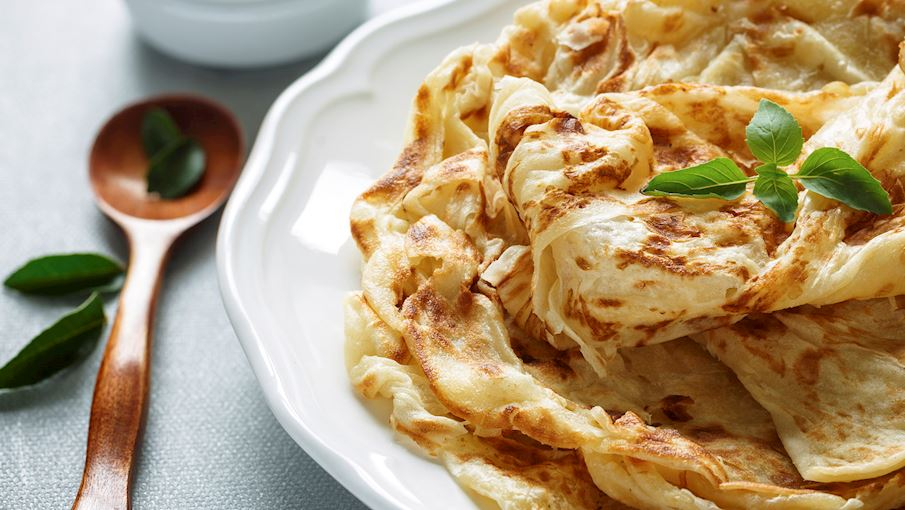 Một trong những m&oacute;n ăn s&aacute;ng phổ biến ở Malaysia l&agrave; roti canai, một loại b&aacute;nh m&igrave; dẹt c&oacute; nguồn gốc từ Ấn Độ. B&aacute;nh được l&agrave;m từ bột m&igrave;, nước, muối v&agrave; bơ, sau đ&oacute; c&aacute;n mỏng, gấp lớp v&agrave; nướng tr&ecirc;n chảo n&oacute;ng. Khi thưởng thức, người ta thường chấm c&ugrave;ng c&agrave; ri, đậu lăng hoặc sữa đặc để tăng th&ecirc;m hương vị. Vỏ b&aacute;nh gi&ograve;n rụm nhưng b&ecirc;n trong lại dai mềm, tạo cảm gi&aacute;c ngon miệng. Kh&ocirc;ng chỉ phổ biến ở Malaysia, m&oacute;n n&agrave;y c&ograve;n được y&ecirc;u th&iacute;ch tại Singapore v&agrave; Brunei.