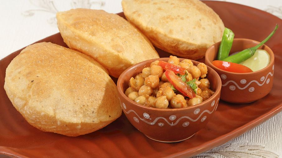 Chole bhature l&agrave; một bữa s&aacute;ng nổi tiếng ở miền Bắc Ấn Độ, đặc biệt tại Punjab. M&oacute;n ăn bao gồm chole &ndash; c&agrave; ri đậu g&agrave; cay thơm, ăn k&egrave;m với bhature &ndash; b&aacute;nh m&igrave; chi&ecirc;n phồng v&agrave;ng ruộm. Sự kết hợp giữa vị cay, b&eacute;o v&agrave; độ gi&ograve;n tạo n&ecirc;n hương vị đặc trưng, kh&oacute; cưỡng. Người ta thường d&ugrave;ng chole bhature với h&agrave;nh t&iacute;m, dưa chua v&agrave; lassi để tăng th&ecirc;m sự h&agrave;i h&ograve;a. Đ&acirc;y l&agrave; một m&oacute;n ăn gi&agrave;u năng lượng, l&yacute; tưởng cho những ai muốn bắt đầu ng&agrave;y mới với một bữa ăn no n&ecirc;.