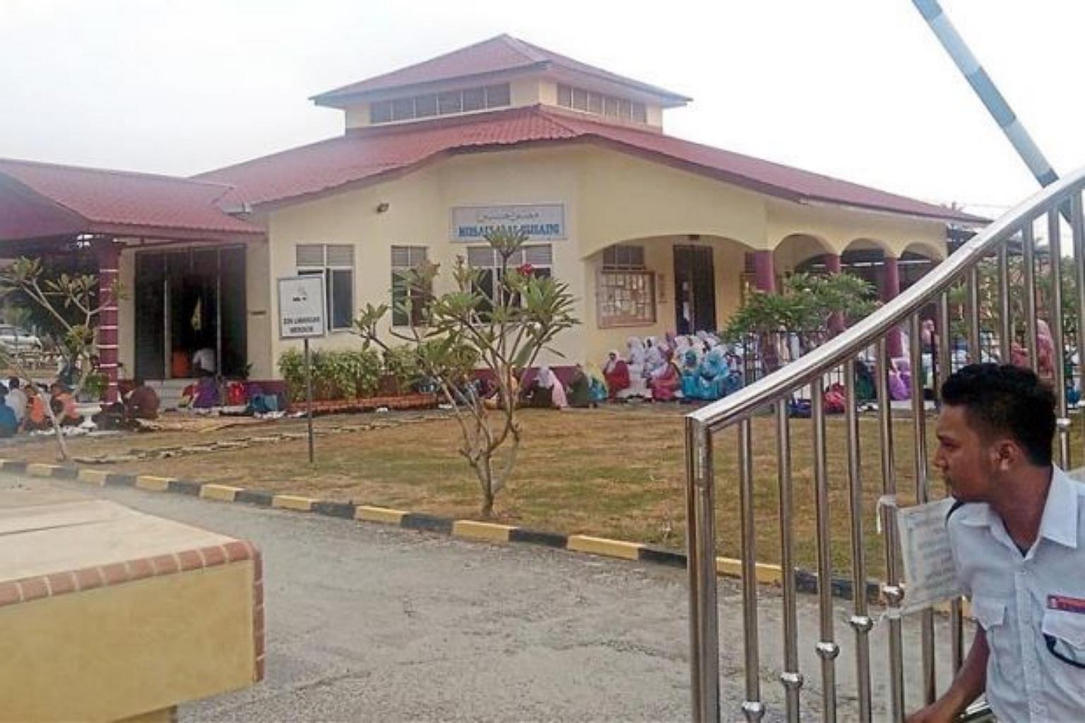 Bảo vệ đ&oacute;ng cổng một trường trung học tại Kelantan, v&agrave;o ng&agrave;y học sinh đi học trở lại. &Iacute;t l&acirc;u trước đ&oacute;, v&igrave; cơn &ldquo;cuồng loạn tập thể&rdquo; đột ngột, trường phải đ&oacute;ng cửa một thời gian. Giữa năm 2016, từng c&oacute; hơn 3 ng&ocirc;i trường ở bang n&agrave;y ghi nhận c&aacute;c vụ việc kỳ lạ tương tự, ảnh hưởng h&agrave;ng trăm học sinh. - Ảnh: StraitsTimes