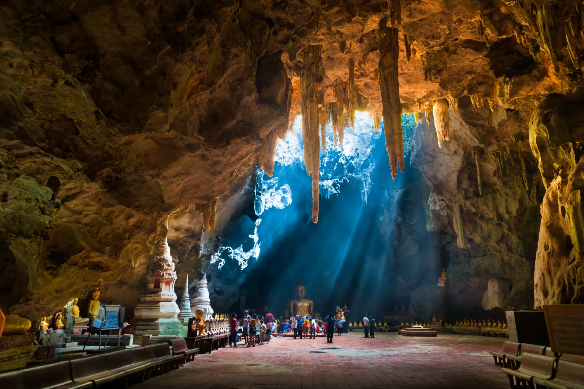 Hang Tham Khao Luang   Ng&ocirc;i đền hang động tr&ecirc;n n&uacute;i rộng lớn v&agrave; y&ecirc;n b&igrave;nh n&agrave;y chứa đầy tượng Phật nằm ở tỉnh Phetchaburi, miền trung Th&aacute;i Lan. Ng&ocirc;i đền n&agrave;y chỉ mới khoảng 100 năm tuổi v&agrave; được x&acirc;ydựng dưới thời vua Chulalongkorn. Khi mặt trời chiếu s&aacute;ng, &aacute;nh s&aacute;ng chiếu v&agrave;o đ&aacute; v&agrave; tạo n&ecirc;n cảnh tượng đầy m&agrave;u sắc. Chỉ cần cẩn thận với những ch&uacute; khỉ kh&oacute; chịu tr&ecirc;n con đường dốc ở đ&oacute; Ảnh: expedia