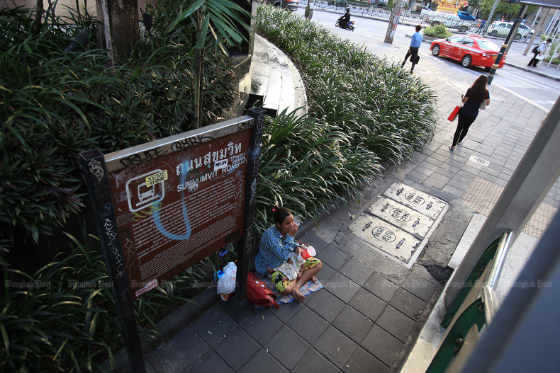 Một phụ nữ bế em b&eacute; xin tiền tại ng&atilde; tư Asok ở Bangkok. Ảnh: Bangkokpost.