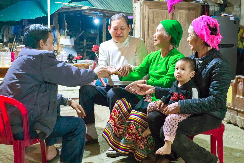 Thầy mo Lữ Trọng Bằng (&aacute;o trắng) t&aacute;i hiện nghi lễ buộc chỉ cổ tay trong lễ đ&oacute;n tiếng sấm - ẢNH: PHAN NGỌC